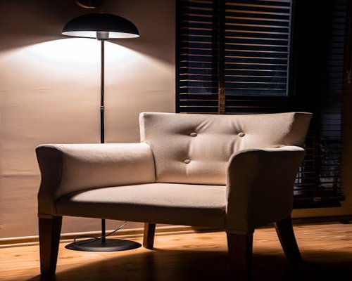 A comfortable modern reading chair positioned under soft ambient light inside an apartment
