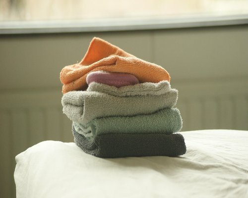 A calm bedroom environment featuring minimalist design and neatly organized soft linen sheets