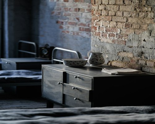 A dim bedroom setting with an analog book open on the side table